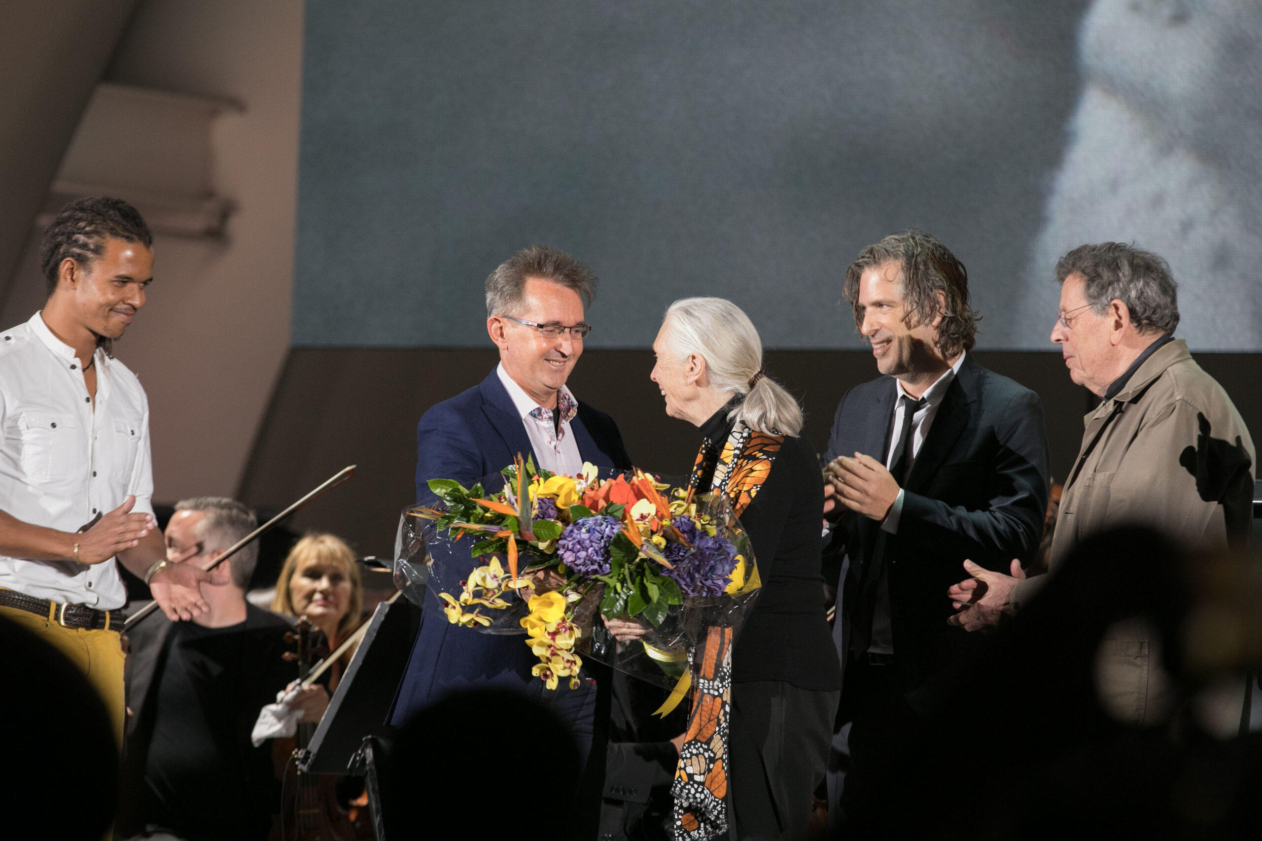 Dr. Jane Goodall is presented flowers by her son Grub van Lawick following the National Geographic screening of the feature documentary JANE. Jane will be in select theaters October 20. (National Geographic/Rebecca Hale)