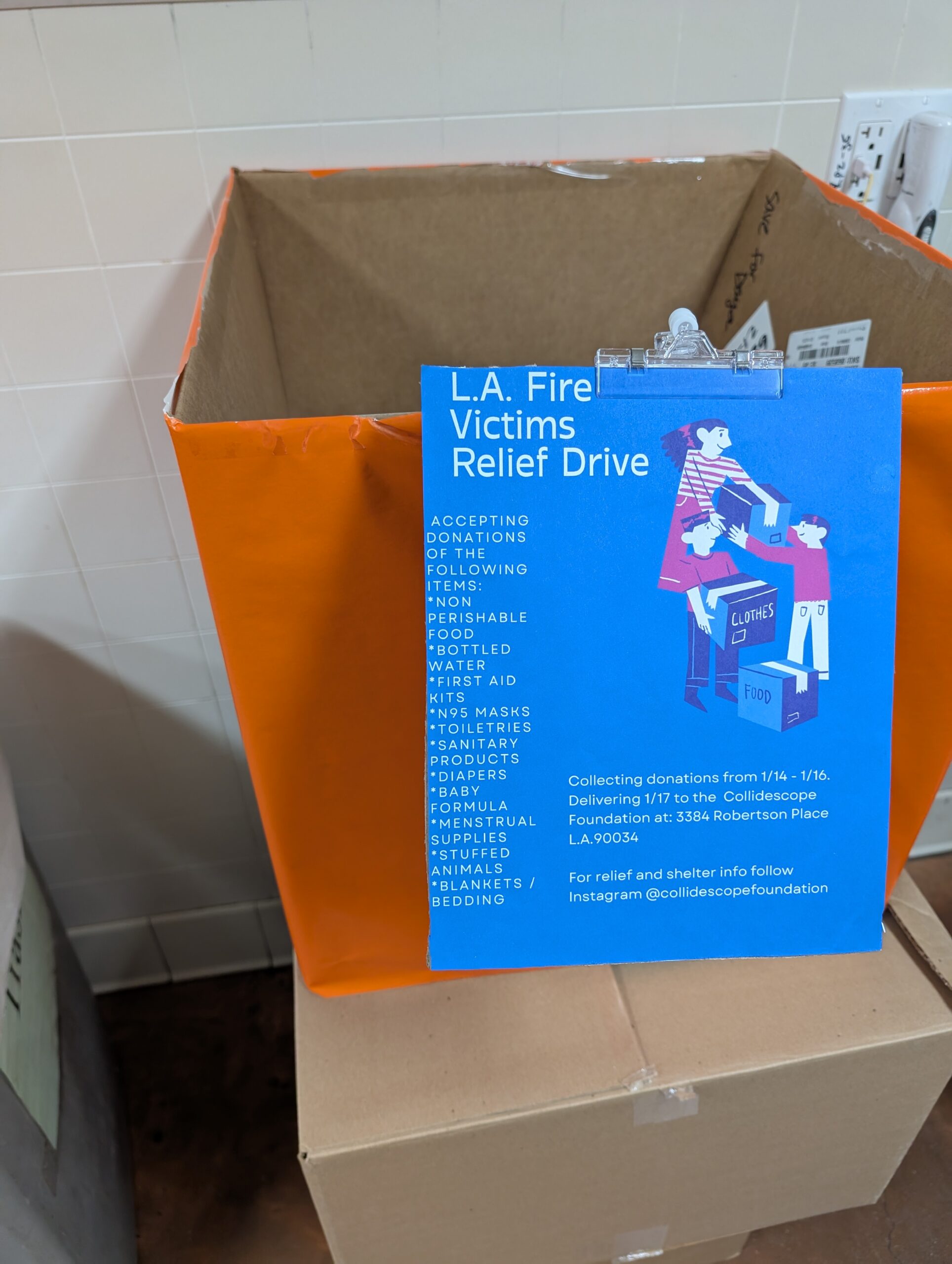 A photo of a cardboard box with a blue sign on it saying "L.A. Fire Victims Relief Drive" and a list of donations needed.