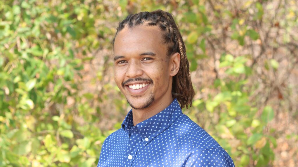 Merlin van Lawick smiling with a blue collared shirt in Gombe National Park.